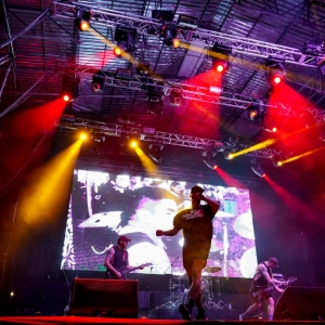 Cantante en tarima con luces  al fondo 